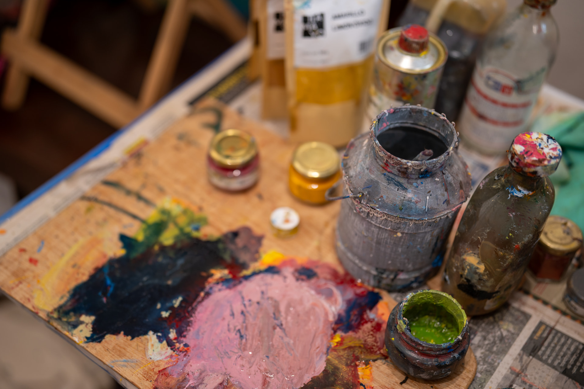 Paleta de madera y frascos de pintura en el estudio